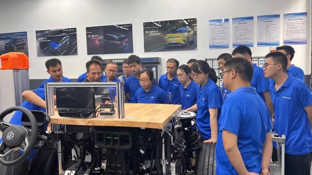 教师围绕汽车教学台架听取实操讲解